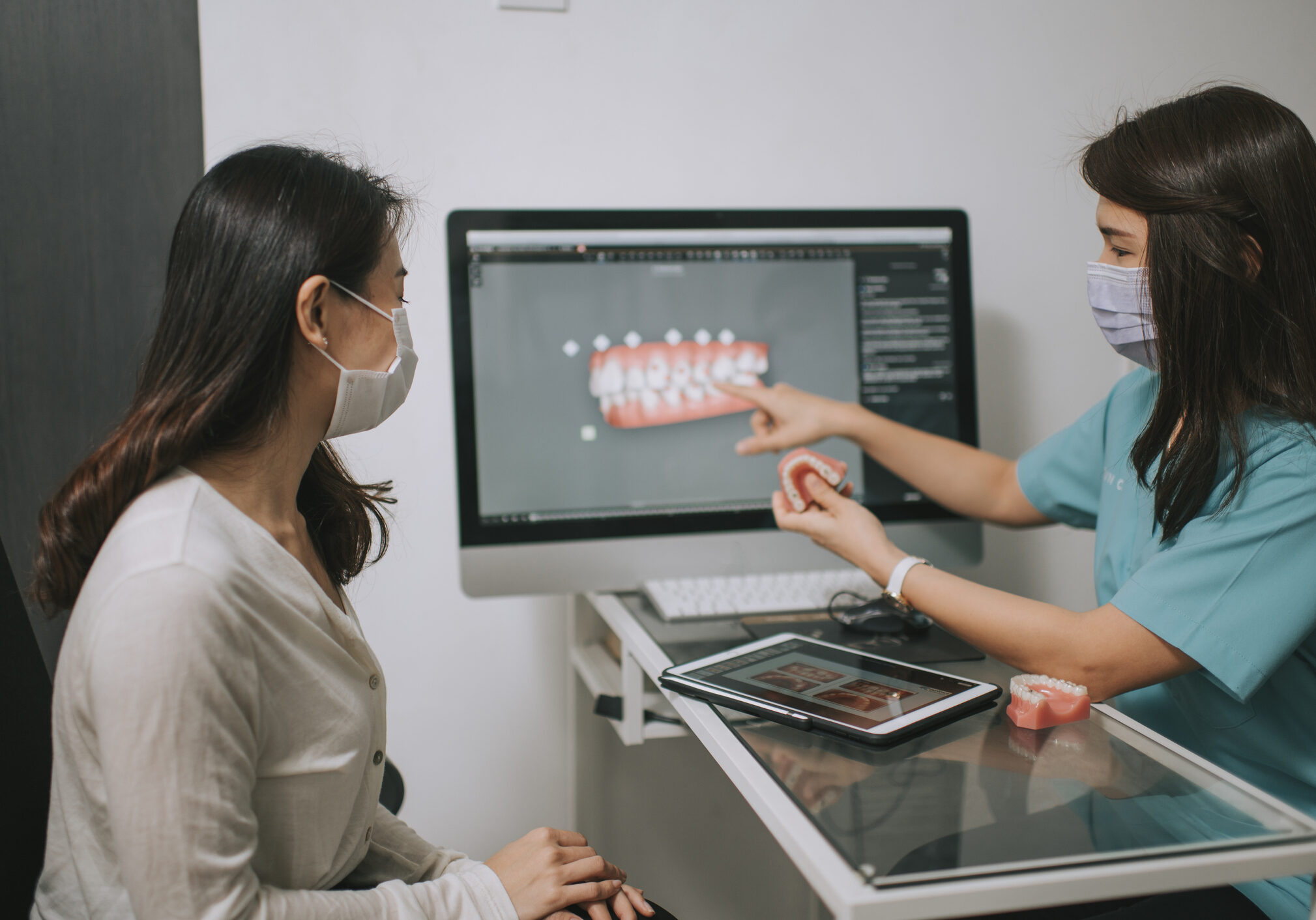 asian chinese female dentist explaining Tooth X-Rays To A Patient